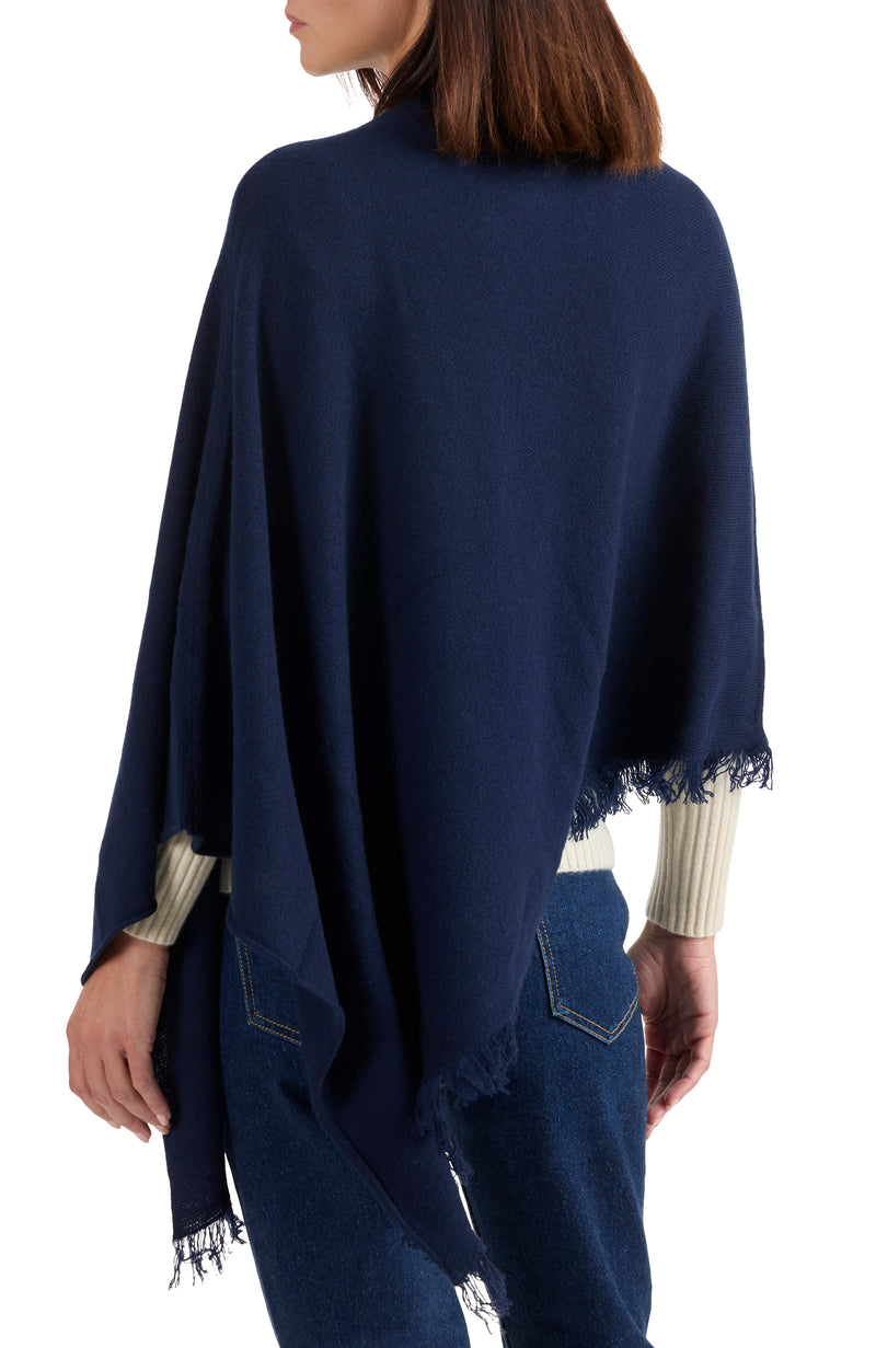 model wearing CASHMERE FRINGE JERSEY ASYMMETRICAL PONCHO in  navy back