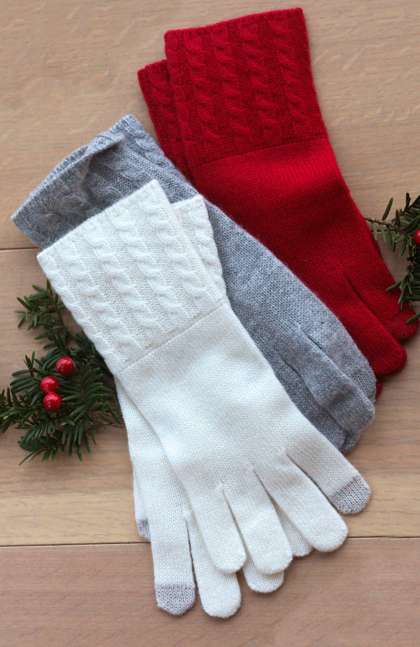 CASHMERE CABLE KNIT CUFF GLOVES LAID ON FLOOR WITH HOLLY AND RED BERRIES in 3 colors: white, grey and red